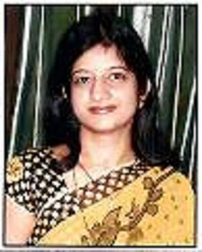 Portrait of Dr. Kapoor wearing traditional attire with academic books in background